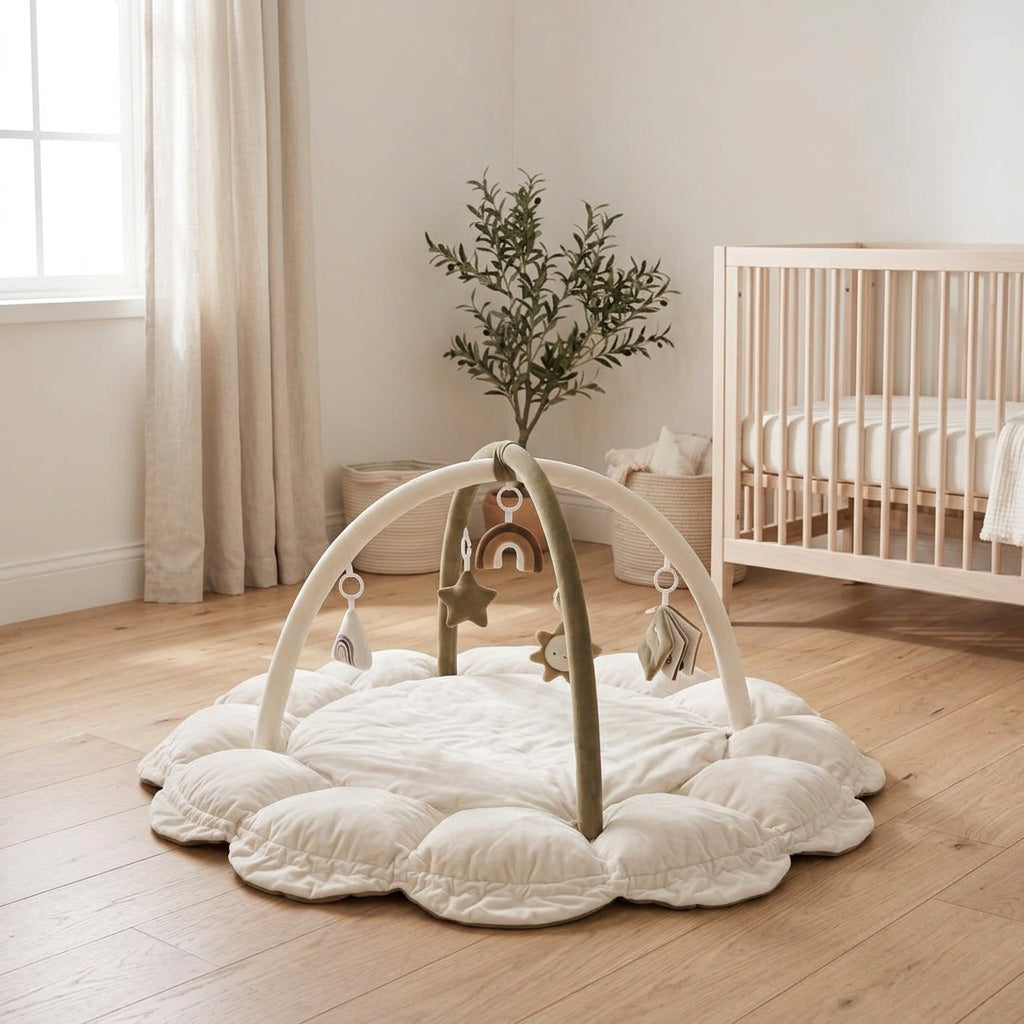 Nid d'éveil Nuage coloris Ivoire Sauge (crème et vert olive) avec arche et jouets suspendus, posé dans une chambre d'enfant